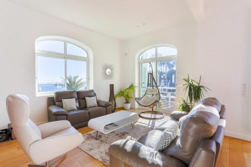 a living room with a leather couch and chairs at Villa de charme moderne avec piscine et vue mer in Nice