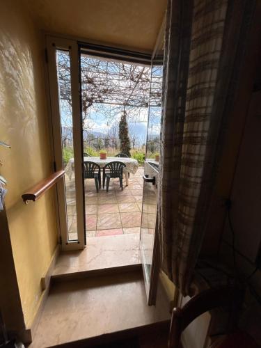 eine offene Tür zu einer Terrasse mit einem Tisch in der Unterkunft Villa Castello in Montefalcione