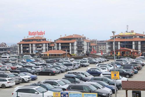 a parking lot filled with lots of parked cars at Great location near lift in Bansko