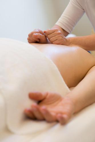 a woman getting a belly massage from a therapist at Wyn. Strandhotel Sylt in Westerland (Sylt)
