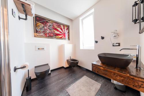 La salle de bains est pourvue d'une baignoire noire et d'un lavabo. dans l'établissement Hotel Castiglione, à Lignano Sabbiadoro
