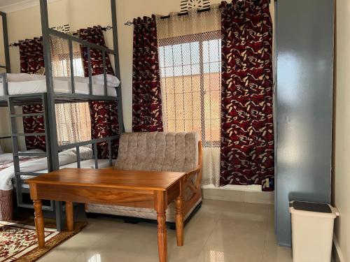 a room with a desk and a chair and bunk beds at Kilimanjaro Trekcity Hostel in Moshi
