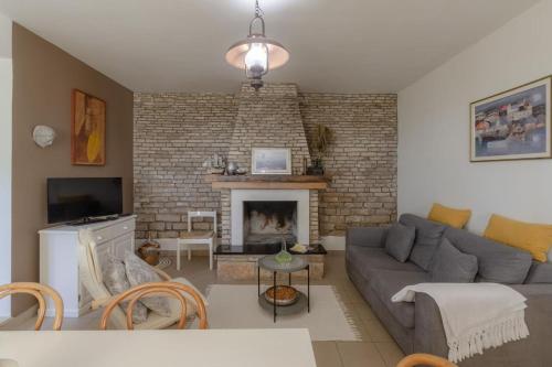 ein Wohnzimmer mit einem Sofa und einem Kamin in der Unterkunft Sea View House Sanja With Terrace - Happy Rentals in Vela Luka