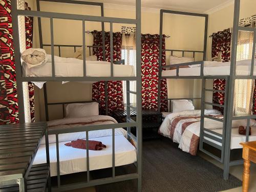 a room with three bunk beds in a room at Kilimanjaro Trekcity Hostel in Moshi