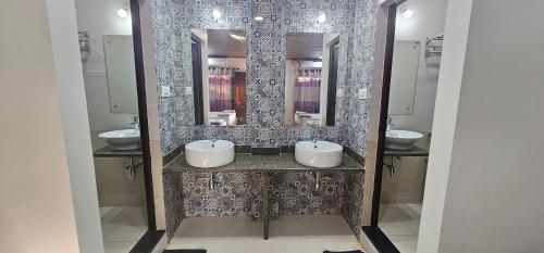 a bathroom with two sinks and two mirrors at Deva Samudra Beach Stay in Gokarna