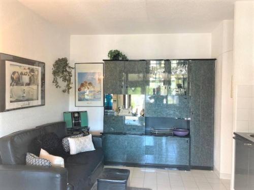 - un salon avec un canapé et un mur en verre dans l'établissement Villa 53, Port Vénus au village naturiste, au Cap d'Agde