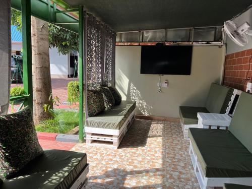 a screened in porch with couches and a television at Kilimanjaro Trekcity Hostel in Moshi