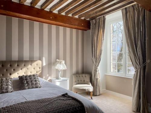 1 dormitorio con 1 cama, 1 silla y 1 ventana en Les Castelets by Melrose, en Barbeville