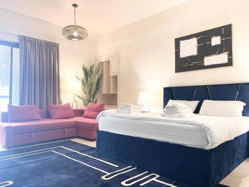 sypialnia z dużym łóżkiem i kanapą w obiekcie Charming spacious studio apartment in the heart of JBR By SWEET HOMES w Dubaju