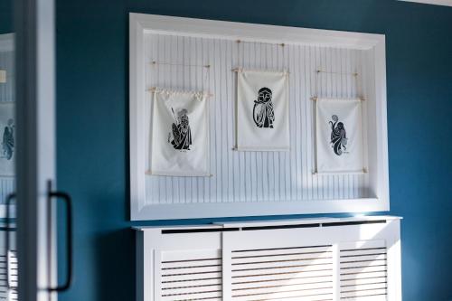 a room with blue walls and a white shelf with pictures at Port Aran House in Kilronan