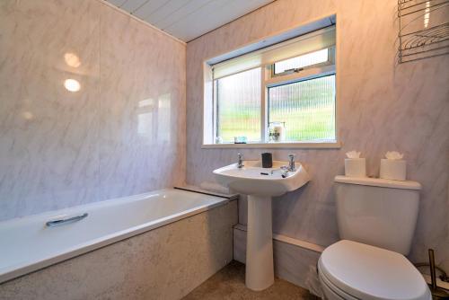 a bathroom with a sink and a toilet and a bath tub at Finest Retreats - Stonelea in Tideswell