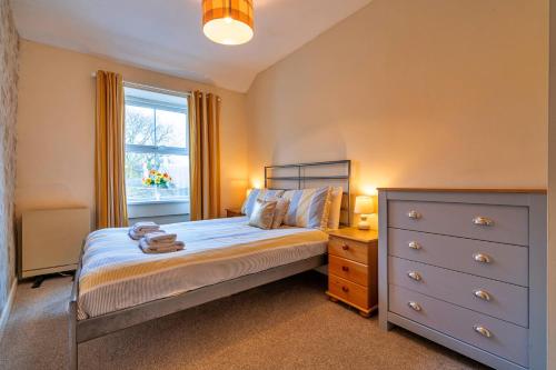 a bedroom with a bed and a dresser and a window at Finest Retreats - Stonelea in Tideswell