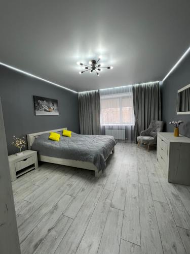 1 dormitorio con 1 cama, 1 silla y 1 ventana en Квартира - студия 72 кв.м, en Uralsk