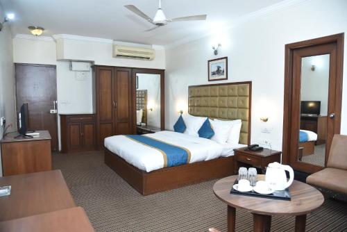 a hotel room with a bed and a living room at BelAir Suites Pune in Pune