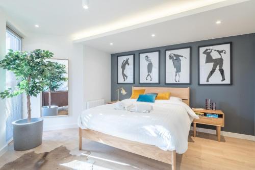 a bedroom with a large bed and a potted tree at Luxury Central Riverside Apartment in Cambridge