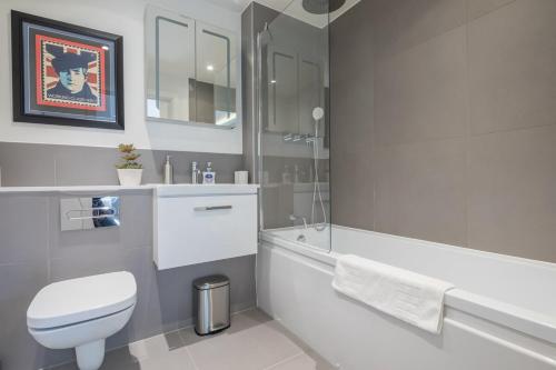 a white bathroom with a toilet and a tub and a sink at Luxury Central Riverside Apartment in Cambridge