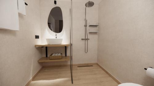 a bathroom with a shower with a sink and a mirror at Elea Terra Hotel in Matala