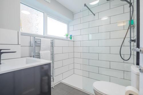 een witte badkamer met een douche en een wastafel bij Chic spacious Cambridge apt in Chesterton