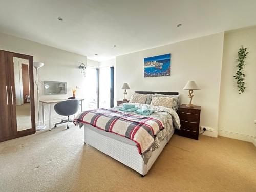 Dormitorio con cama, escritorio y TV en Coastline APT Nearby the Beach, en Swansea