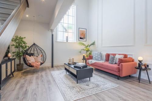 a living room with a red couch and a swing at Deluxe Modern-themed 1 Bedroom Apartment in Cambridge