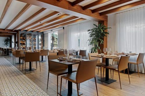 restauracja z drewnianymi sufitami, stołami i krzesłami w obiekcie Prinsotel Mal Pas w Alcudii