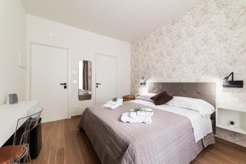 a bedroom with a large bed with towels on it at Casetta Petrera Deluxe Rooms in Bari