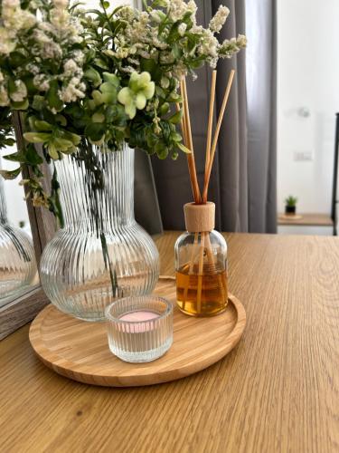a wooden tray with a vase and a bottle of honey at Marina Casa Vacanza in Capoterra