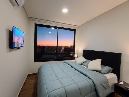 a bedroom with a large bed and a large window at Depto de lujo en zona Carmelitas in Asuncion