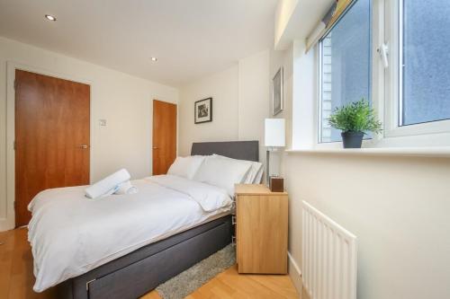 Un dormitorio con una cama grande y una ventana en Large Luxurious CENTRAL Private Terrace - For 6, en Londres