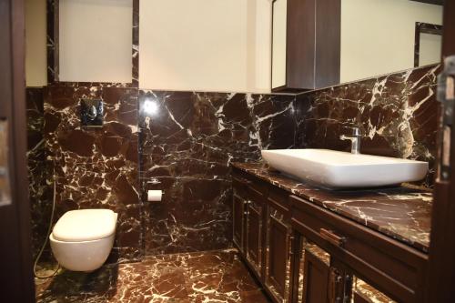 a bathroom with a sink and a toilet at BelAir Suites Pune in Pune