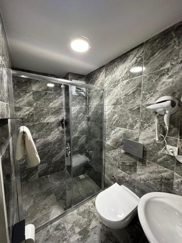 a bathroom with a shower and a toilet and a sink at Kubilay Suite in Istanbul