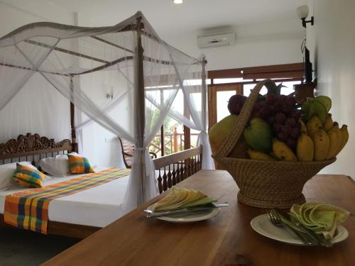 1 dormitorio con una cesta de fruta en una mesa en Swiss Residenz en Weligama