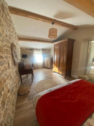 a bedroom with a red bed and a piano at Le Mas Vivarés in Lablachère