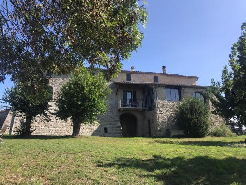 an old stone house with a door in a field at Le Mas Vivarés in Lablachère