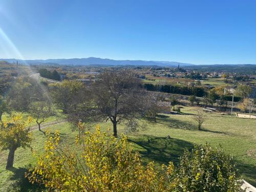 a view of a field with trees and a city at Le Mas Vivarés in Lablachère