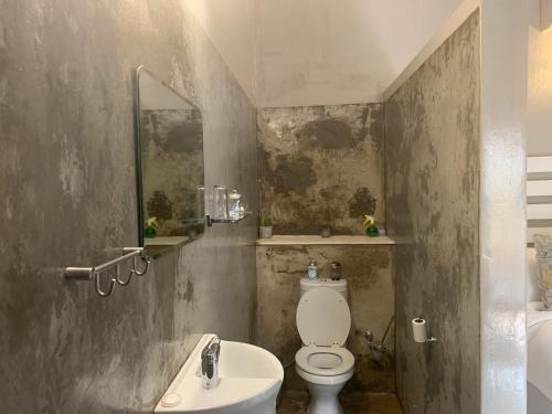 uma casa de banho com um WC branco e um lavatório. em Meraki Upmarket Guesthouse em Rustenburg