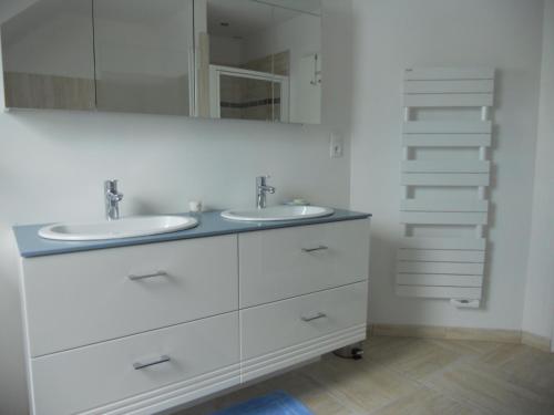biała łazienka z 2 umywalkami i lustrem w obiekcie Maison d'Hôtes le Clos Spinoza w mieście Saint-Planchers