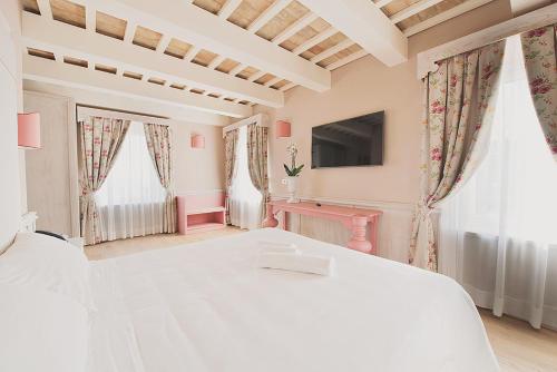 a bedroom with a white bed and a tv at Officina del Sole in Montegiorgio