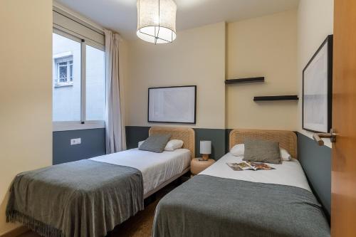 two beds in a room with a window at AB Sagrada Familia - Sant Pau in Barcelona