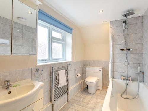 a bathroom with a shower toilet and a sink at 4 Bed in Barnstaple ELLER in Fremington