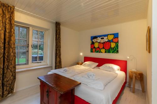 een slaapkamer met een rood bed en een raam bij Vakantievilla - Valkenisseweg 68 - Biggekerke 'Strand Villa' in Biggekerke