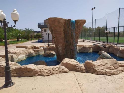 Sharm el shiekh sports city في شرم الشيخ: نافورة مائية في حديقة بها صخور