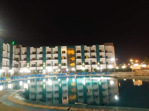 Sharm el shiekh sports city في شرم الشيخ: مبنى كبير أمامه مسبح في الليل
