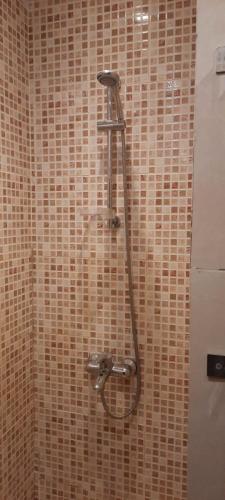y baño con ducha y pared de azulejos marrones. en Sharm el shiekh sports city en Sharm El Sheikh
