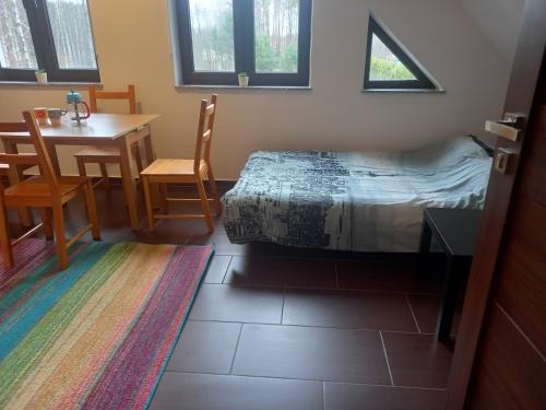 Schlafzimmer mit einem Bett, einem Tisch und Stühlen in der Unterkunft Olesiówka in Nowinka