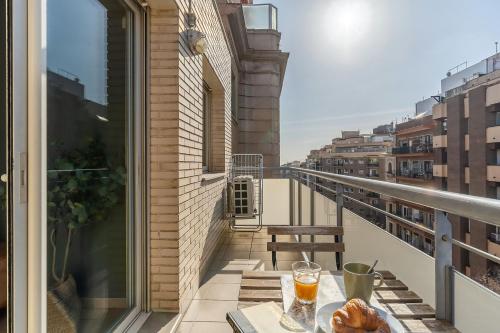 a balcony with a table with a glass of orange juice at AB Sagrada Familia - Sant Pau in Barcelona