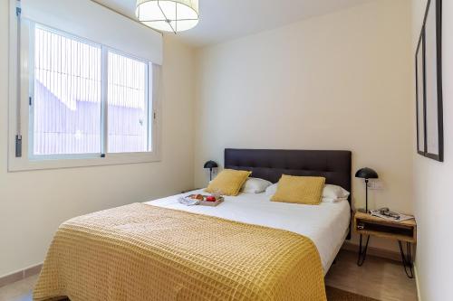 a bedroom with a bed with yellow sheets and a window at AB Sagrada Familia - Sant Pau in Barcelona