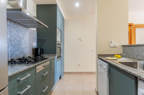 a kitchen with blue cabinets and a sink at AB Sagrada Familia - Sant Pau in Barcelona