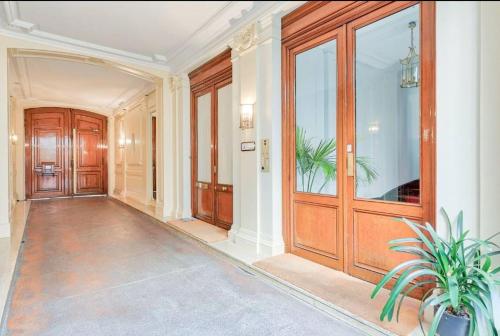 un couloir vide avec une grande porte en bois dans l'établissement Joli appartement Champs Elysées - 6P, à Paris