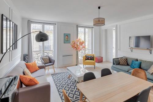 un salon avec un canapé et une table dans l'établissement Joli appartement Champs Elysées - 6P, à Paris